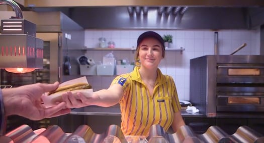 IKEA worker, passing food to a customer