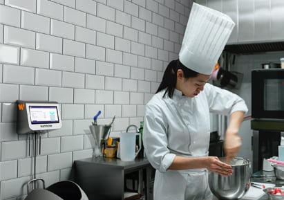 Chef baking in a kitchen with a food waste management technology